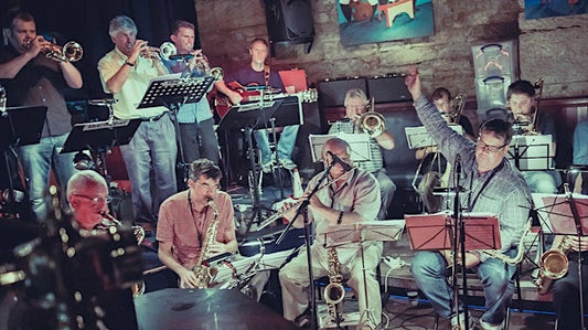 Jazz band performing on stage with instruments and musicians.